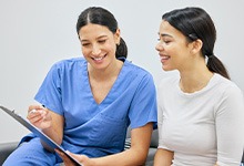 Patient and dental team member reviewing paperwork