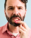 man pointing to inflamed gums 