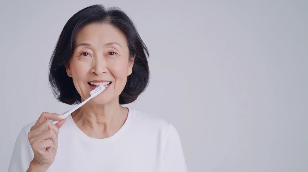 An older woman brushing her teeth.